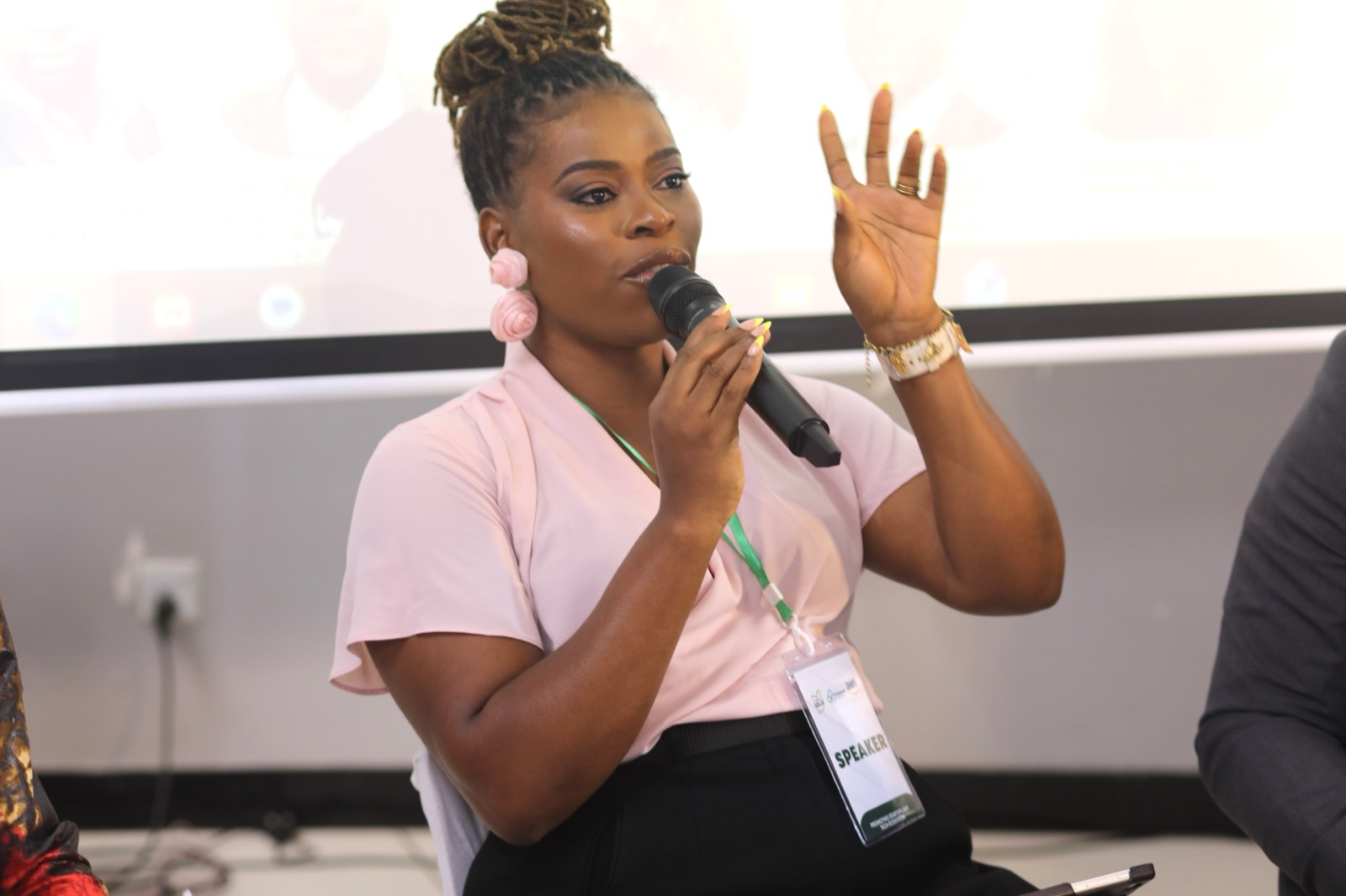 A speaker holding a microphone addresses the room during a Startup Abuja session.